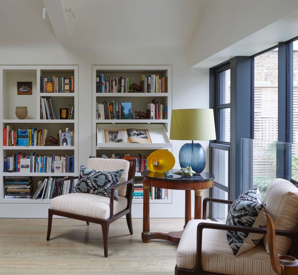 Pair of rattan backed occasional chairs, mahogany and marble centre table and bookshelves with display drawers