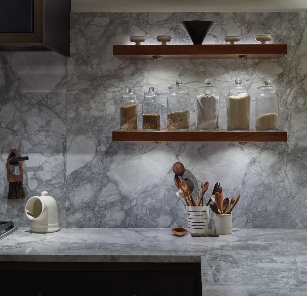 Glass jars in a London kitchen with marble splashbacks and worktop with lighting by John Cullen Lighting