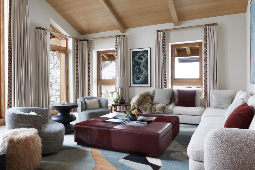 Luxurious interior designed family chalet drawing room with double height ceilings Bill Amberg hair on hide ottoman boucle modular sofare