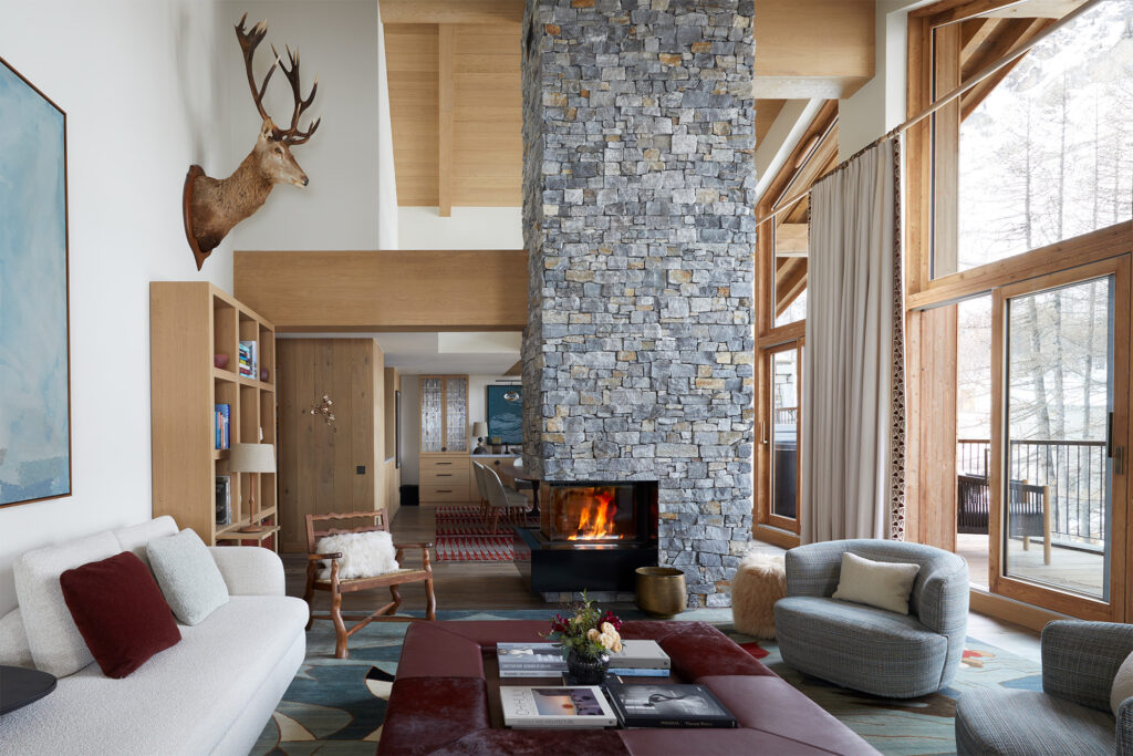 Luxurious interior designed family chalet in Val d'Isere with central chimney stack, stag head, swivel armchair